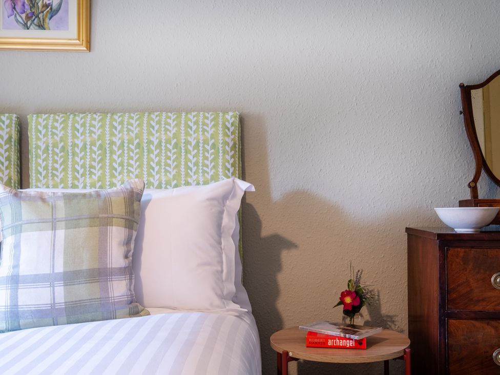A bedroom with a bed and side table at Palace Garden Cottage in Bishop Auckland