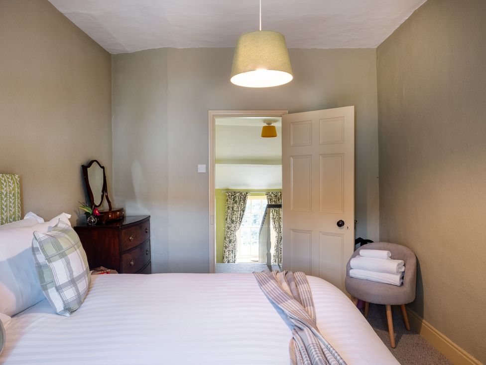 A bedroom with a bed and dresser at Palace Garden Cottage in Bishop Auckland
