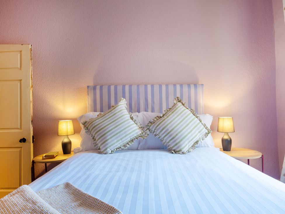 A bedroom with a bed and lamps at Palace Garden Cottage in Bishop Auckland