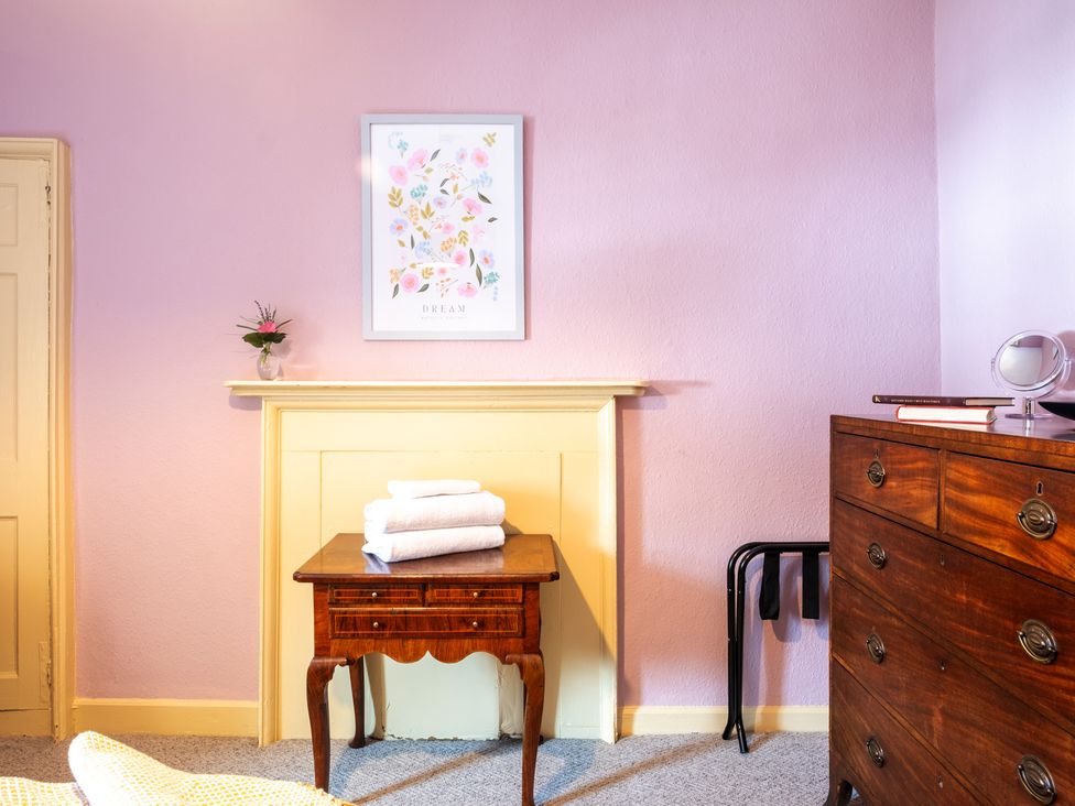 A bedroom with a table and towels at Palace Garden Cottage in Bishop Auckland