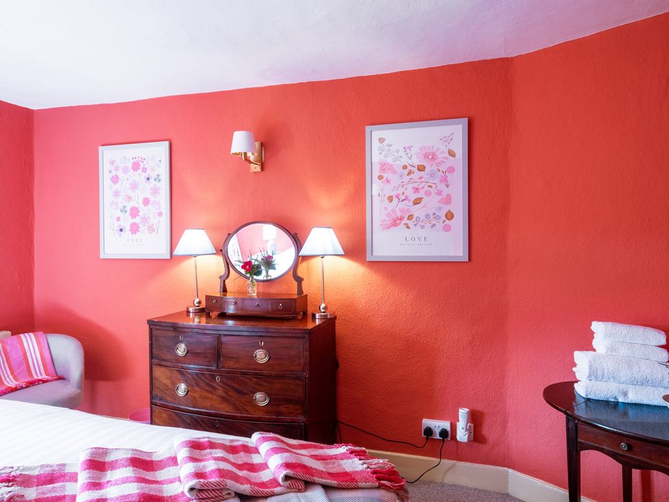 A bedroom with a bed and chest of drawers at Palace Garden Cottage in Bishop Auckland