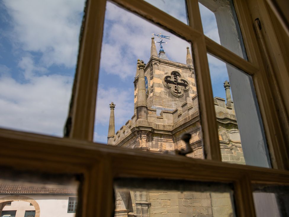 A view of a church tower through a window at Palace Garden Cottage in Bishop Auckland