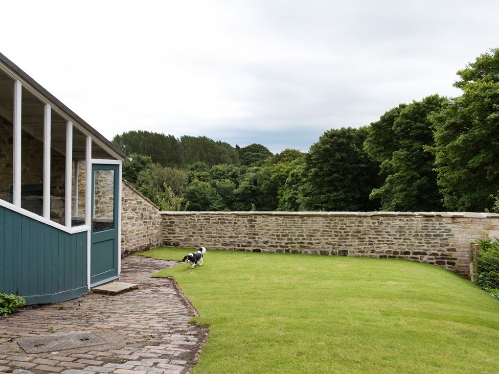 An outdoor area with a dog on grass at Palace Garden Cottage in Bishop Auckland