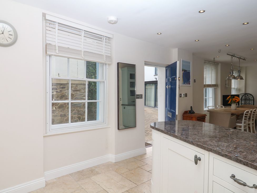 A kitchen with a blue door and dining area at Dennings House, Mayors Avenue Dartmouth