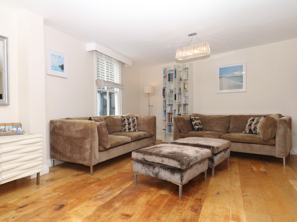 A living room with sofas and a bookshelf at Dennings House, Mayors Avenue, Dartmouth