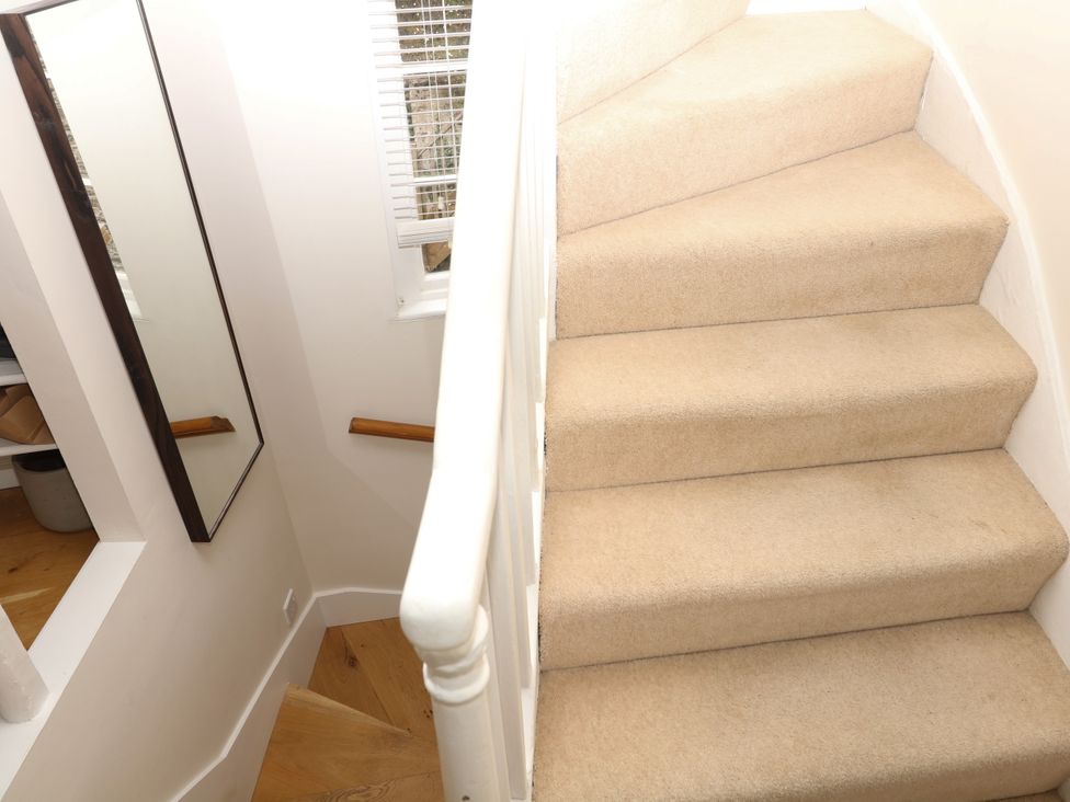 A staircase with a mirror and window at Dennings House, Mayors Avenue in Dartmouth