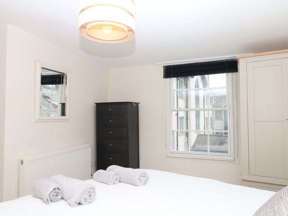 A bedroom with a bed, towels, and a chest of drawers at Dennings House, Mayors Avenue, Dartmouth