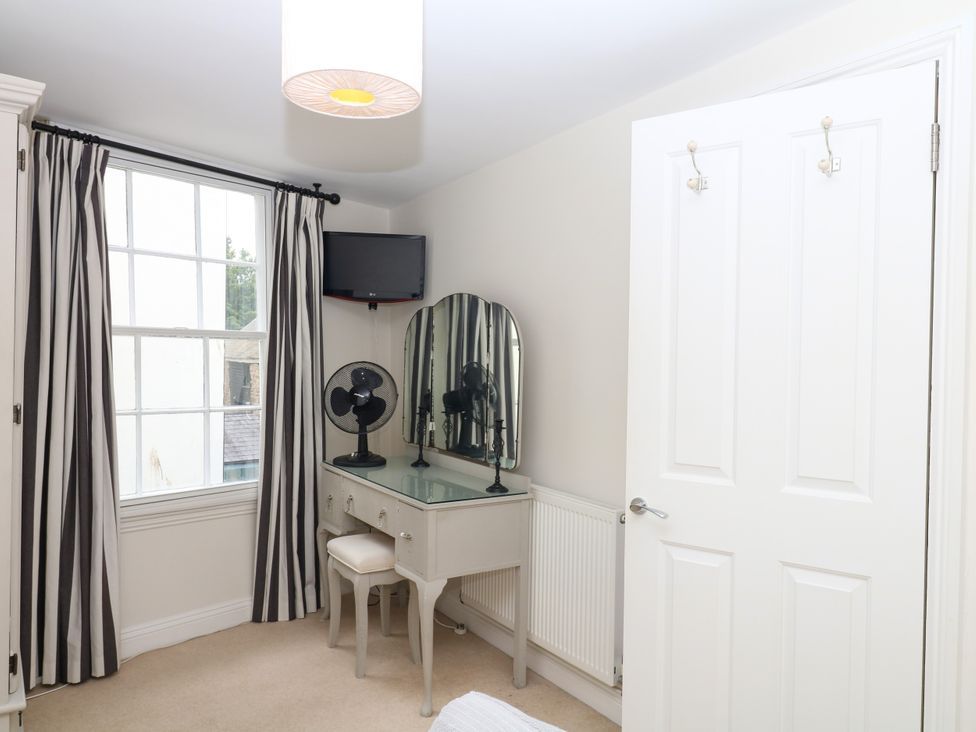 A bedroom with a vanity table and a television at Dennings House, Mayors Avenue in Dartmouth