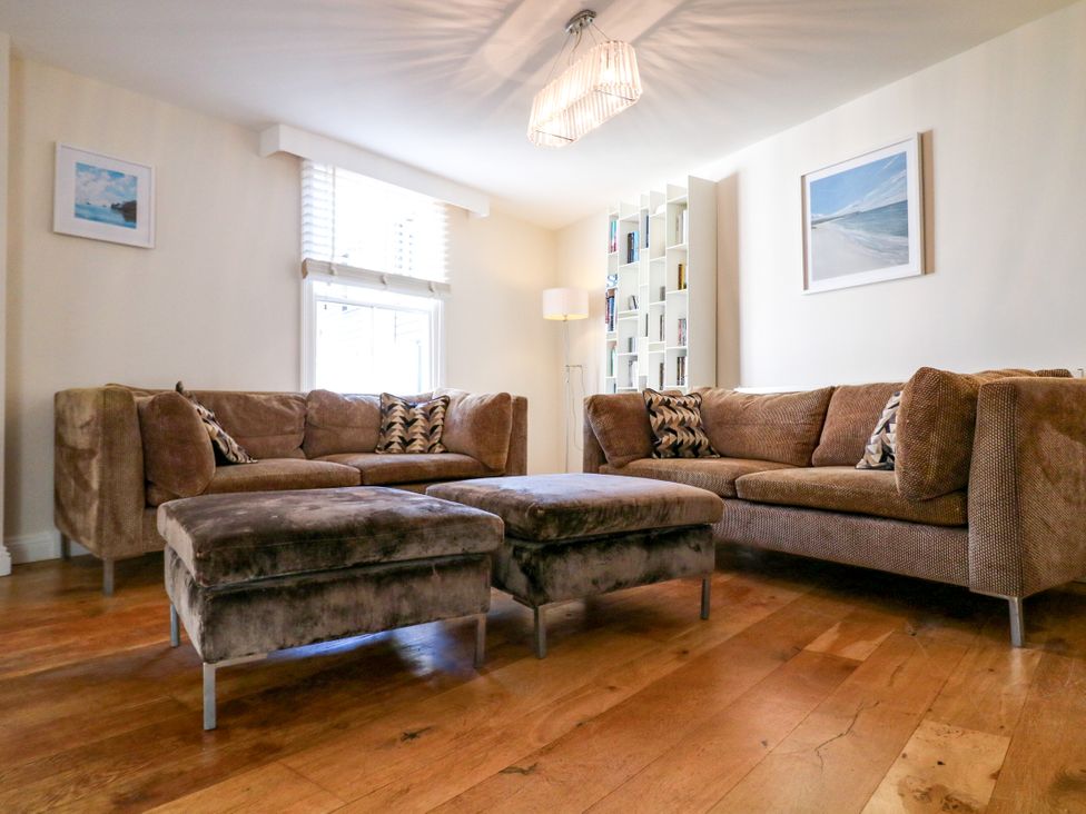 A living room with couches and an ottoman at Dennings House, Mayors Avenue Dartmouth