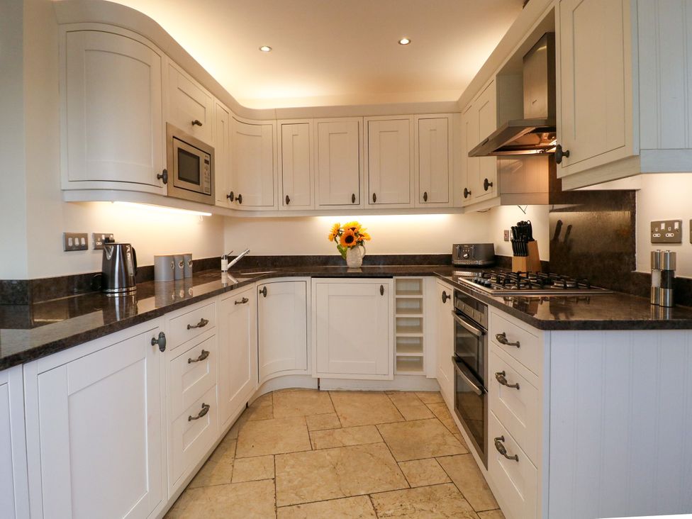 A kitchen with cupboards, stove, and microwave at Dennings House, Mayors Avenue in Dartmouth