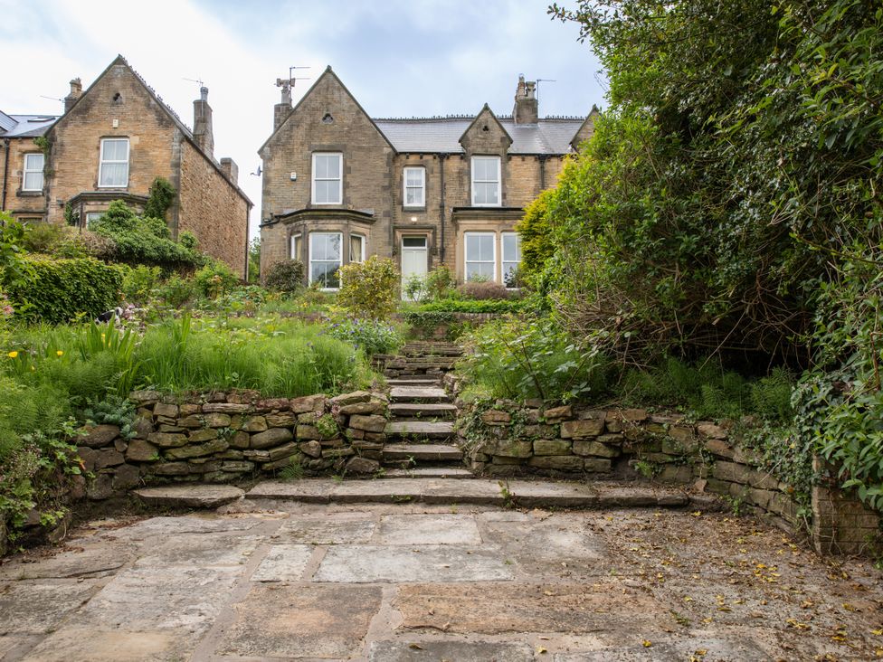 An outdoor area with well-kept garden and steps leading to a house at The Clarence in Bishop Auckland