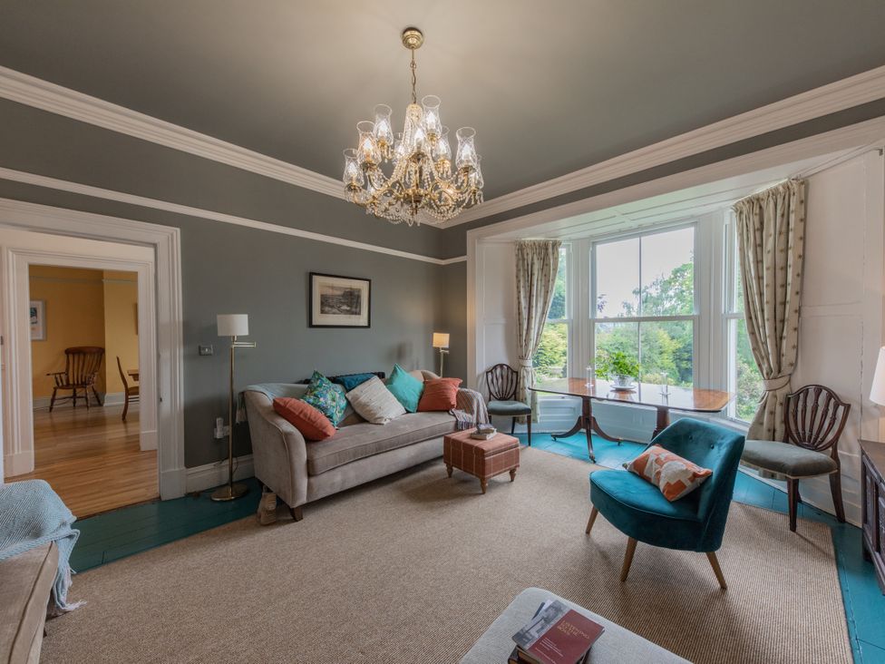 A living room with a chandelier and seating at The Clarence in Bishop Auckland