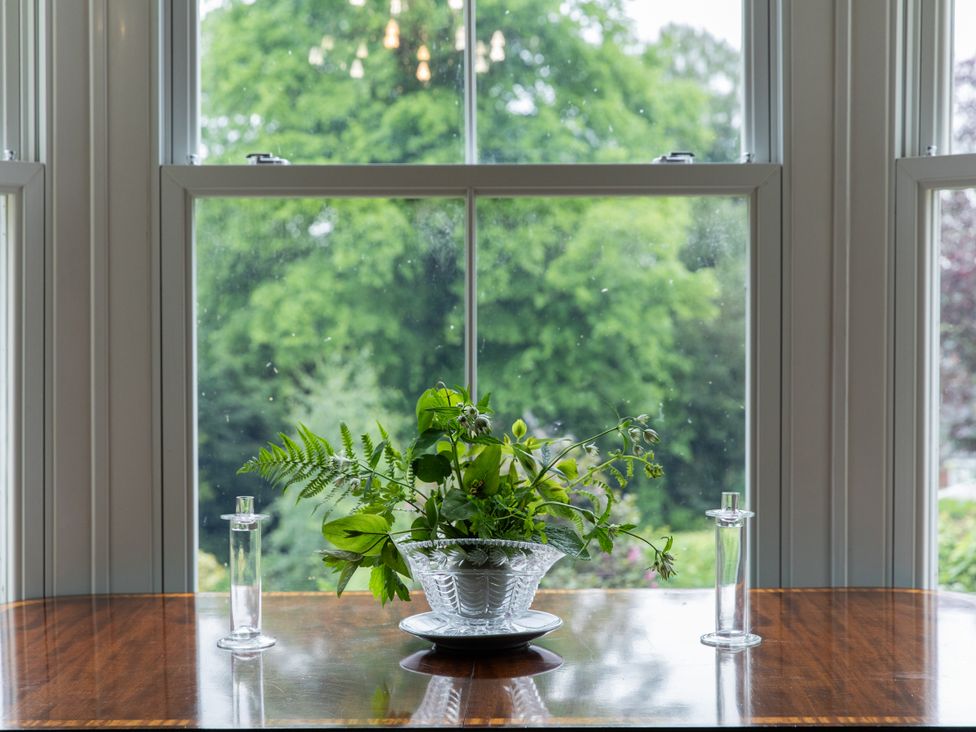 A dining room table with a vase of flowers and candlesticks at The Clarence in Bishop Auckland
