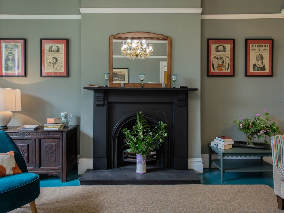 A living room with a fireplace and a mirror at The Clarence in Bishop Auckland