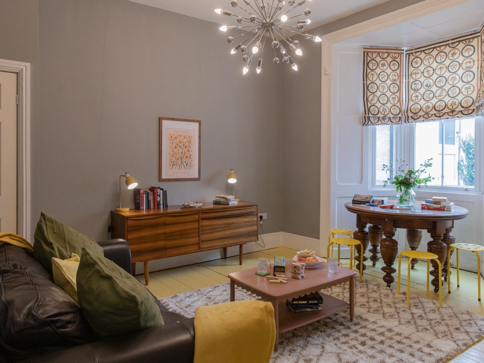A living room with a sofa, table, and bookshelf at The Clarence in Bishop Auckland