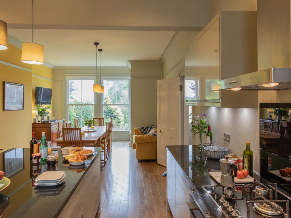 A kitchen with a dining area and bottles on the counter at The Clarence in Bishop Auckland