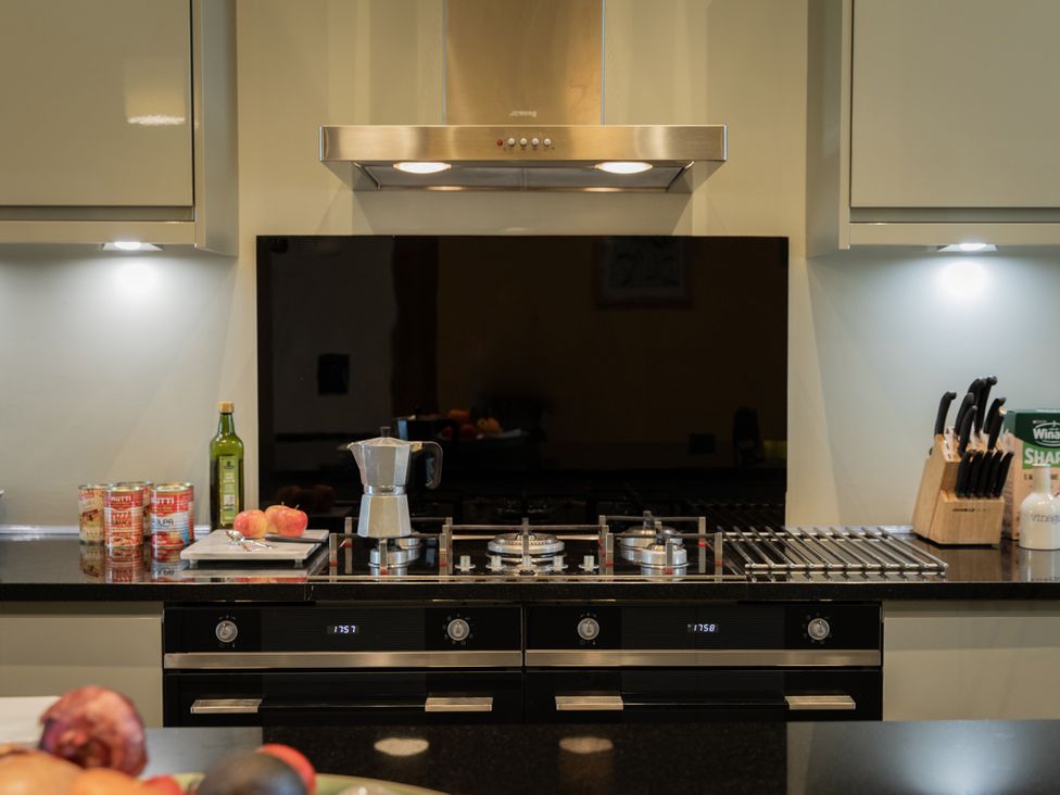 A kitchen with a cooking stove and kitchen hood at The Clarence in Bishop Auckland