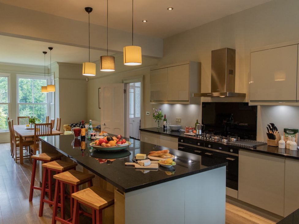A kitchen featuring an island with stools and a dining table at The Clarence in Bishop Auckland
