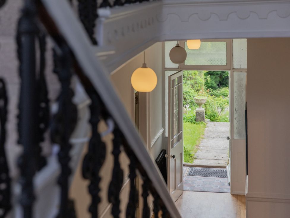 A hallway with a staircase and door leading to a garden at The Clarence in Bishop Auckland