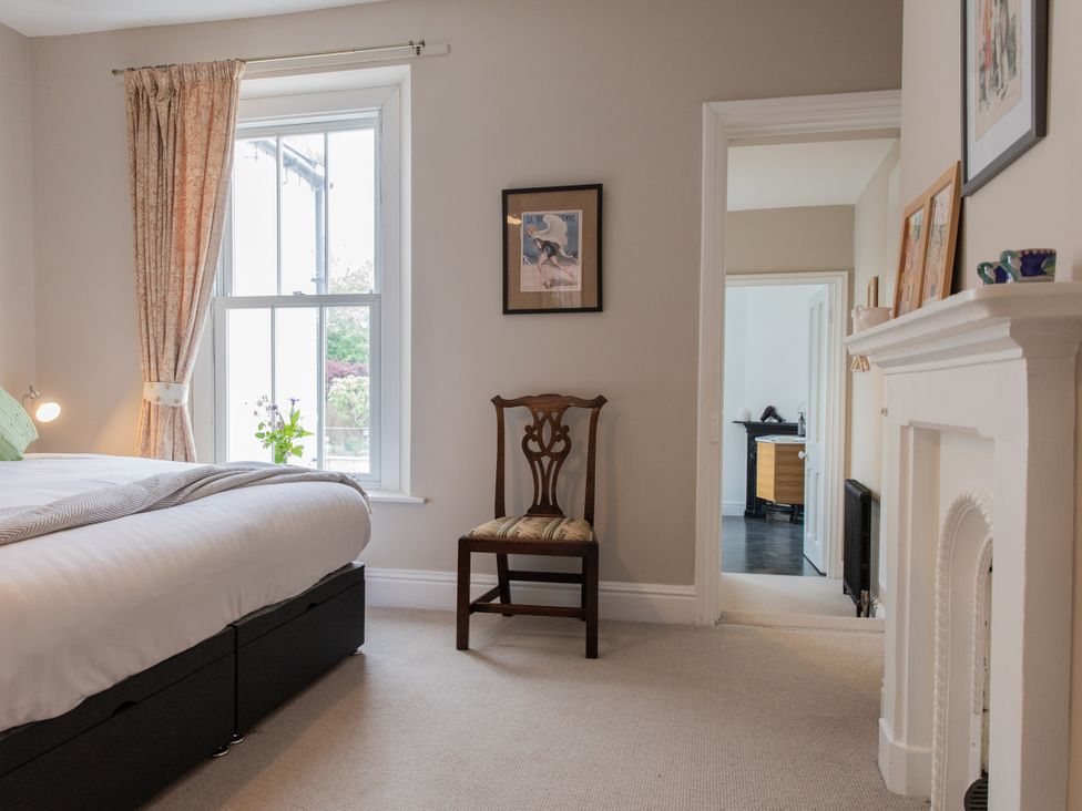 A bedroom with a bed and a chair at The Clarence in Bishop Auckland