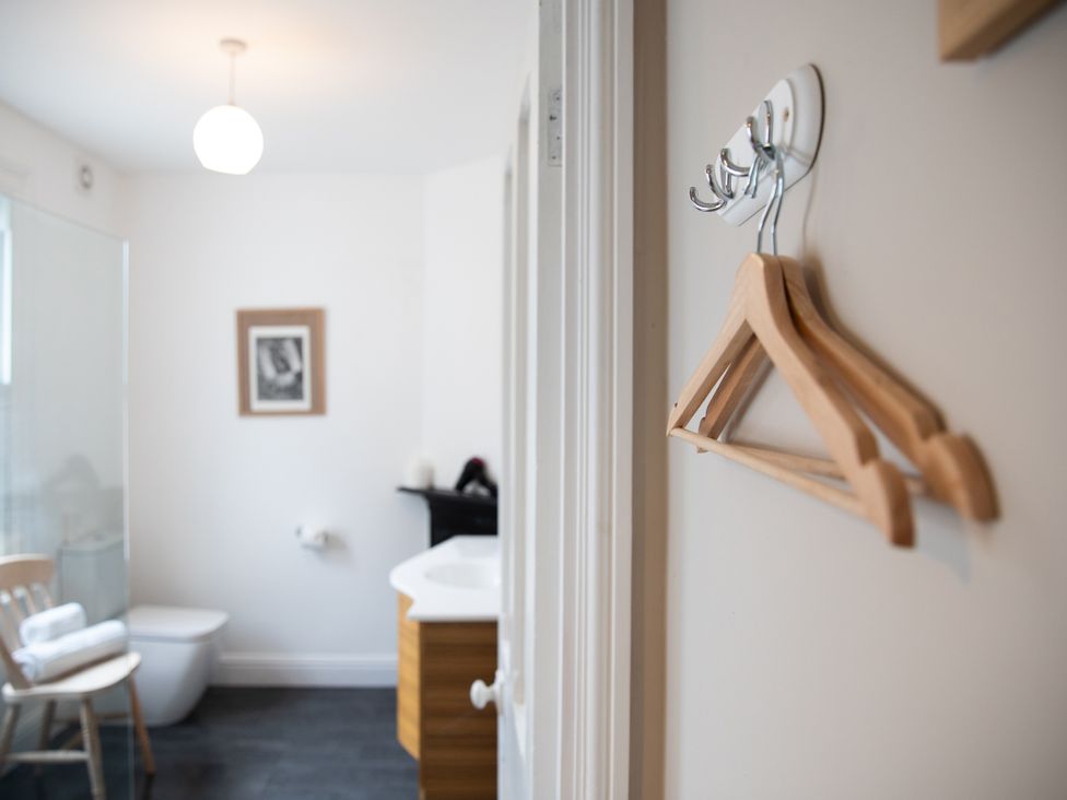 A bathroom with a sink, toilet, and wooden hangers at The Clarence in Bishop Auckland