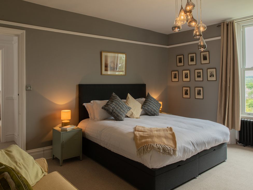 A bedroom with a bed, decorative pillows, and a nightstand at The Clarence in Bishop Auckland