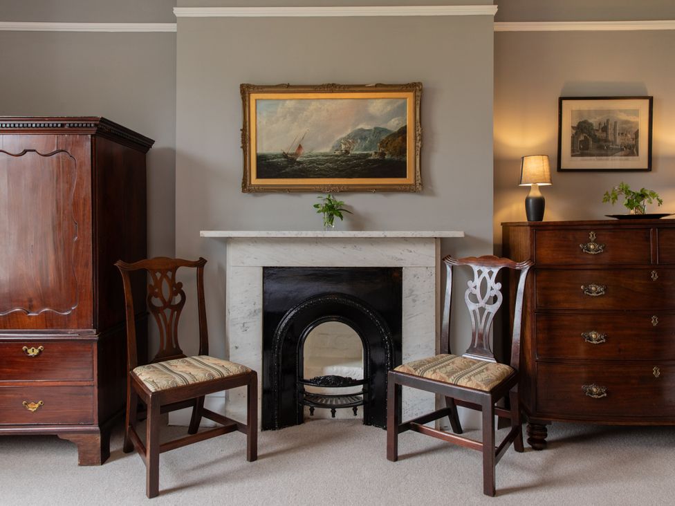 A living room with an armoire and a fireplace at The Clarence in Bishop Auckland