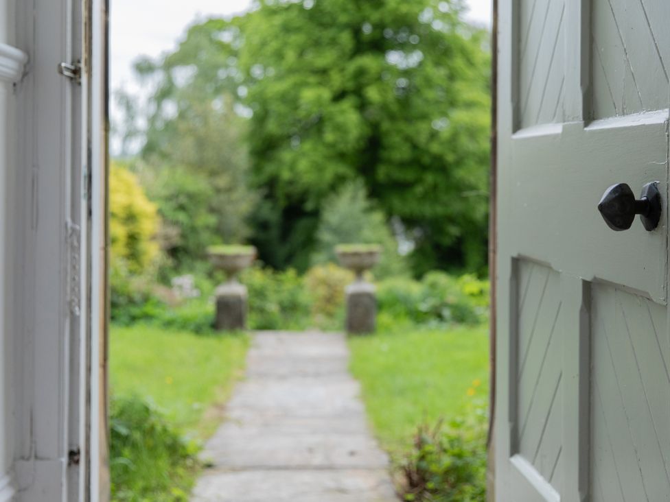 An entrance view to a garden with a pathway and planters at The Clarence in Bishop Auckland