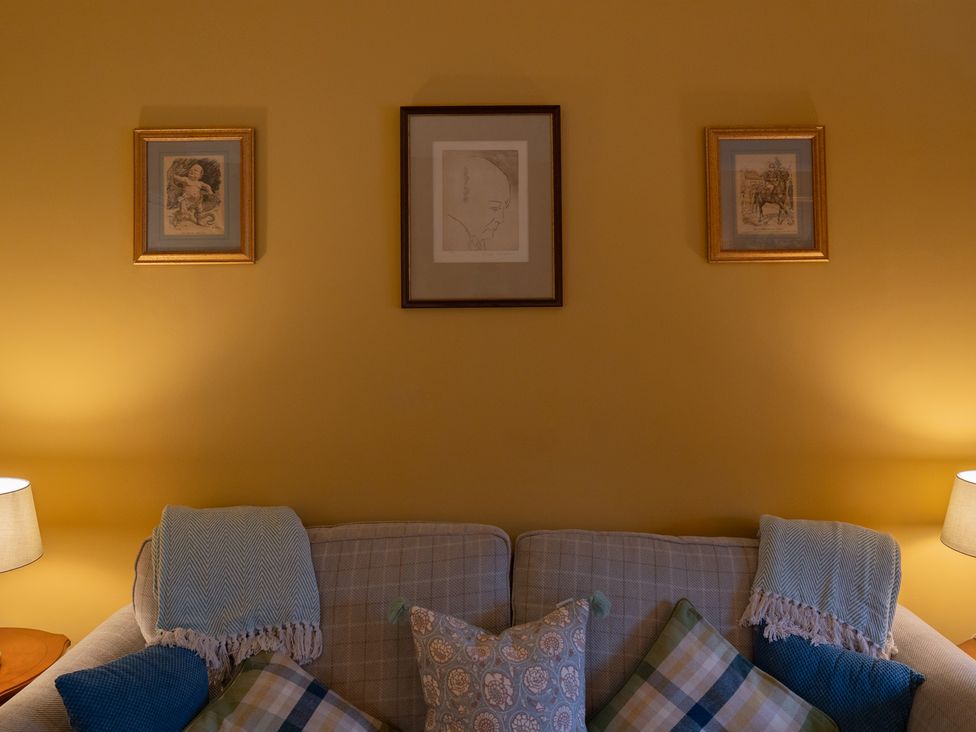 A living room with a sofa and decorative pictures on the wall at Churchill Cottage in Bishop Auckland