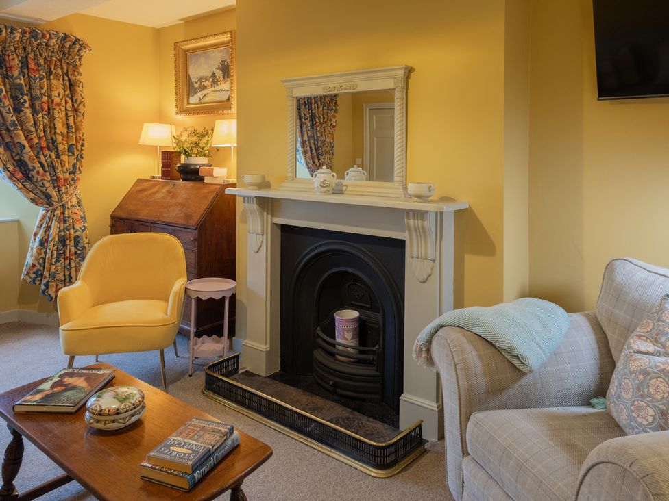 A living room with a fireplace and furniture at Churchill Cottage in Bishop Auckland