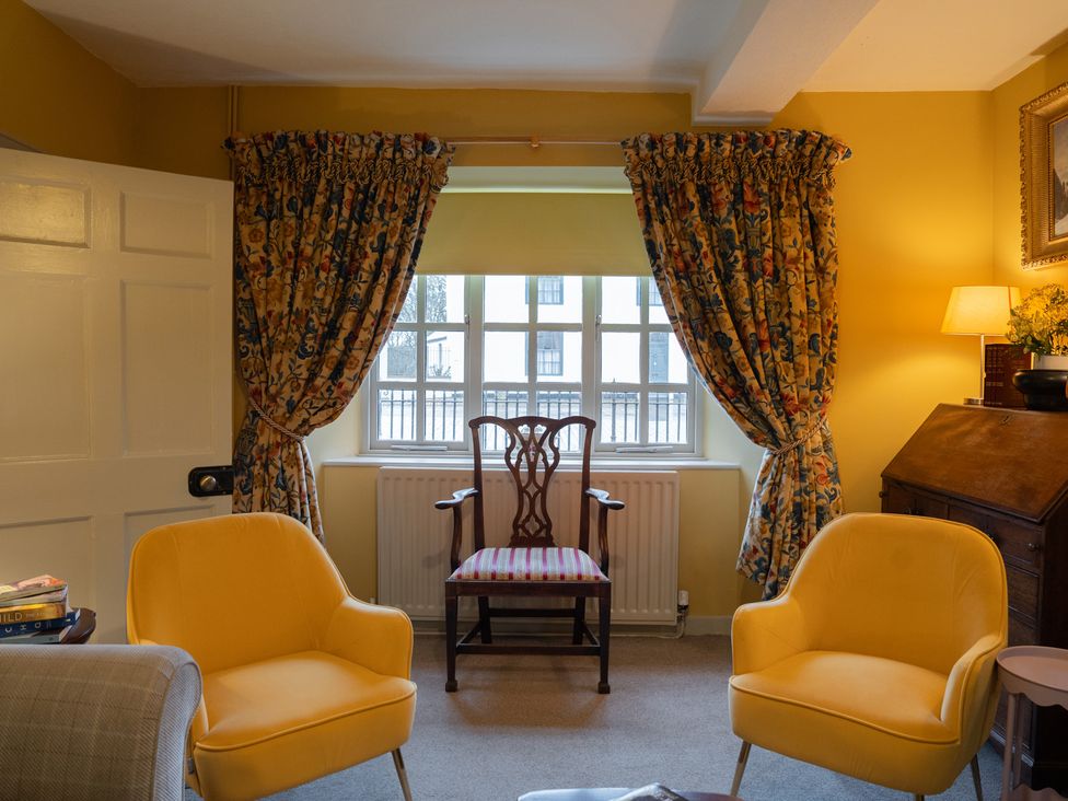 A living room with yellow walls and furniture at Churchill Cottage in Bishop Auckland