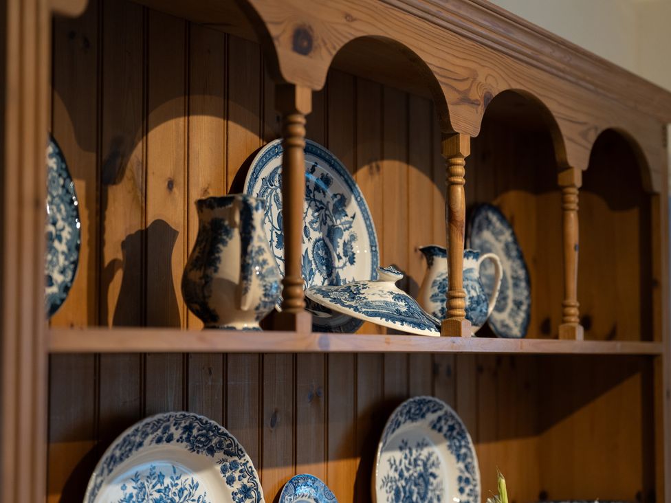 A display of blue and white crockery on a wooden shelf at Churchill Cottage in Bishop Auckland