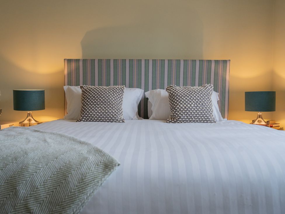 A bedroom with a bed and lamps at Churchill Cottage in Bishop Auckland