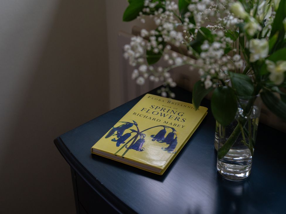 A book and flowers on a table at Churchill Cottage in Bishop Auckland