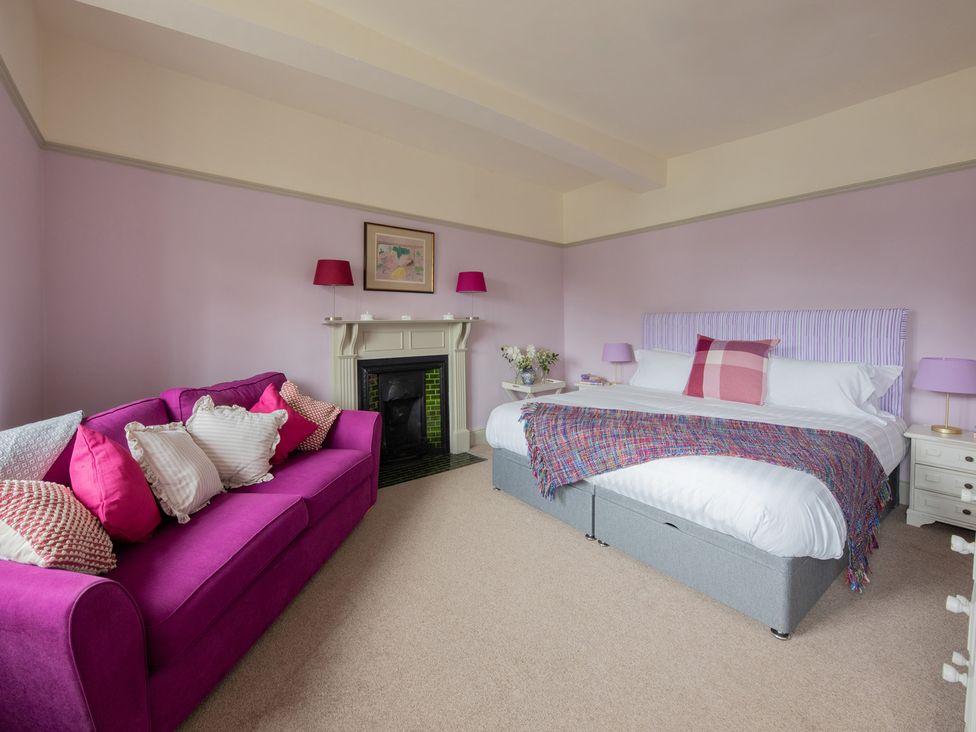 A bedroom with a bed and sofa at Churchill Cottage in Bishop Auckland