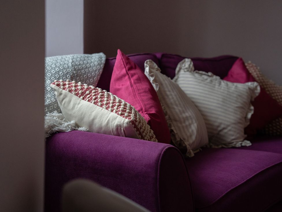A sofa with cushions at Churchill Cottage in Bishop Auckland