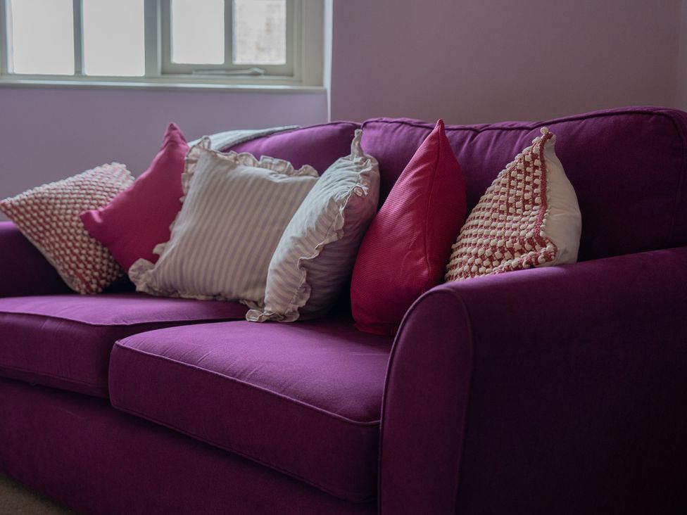 A sofa with cushions at Churchill Cottage in Bishop Auckland