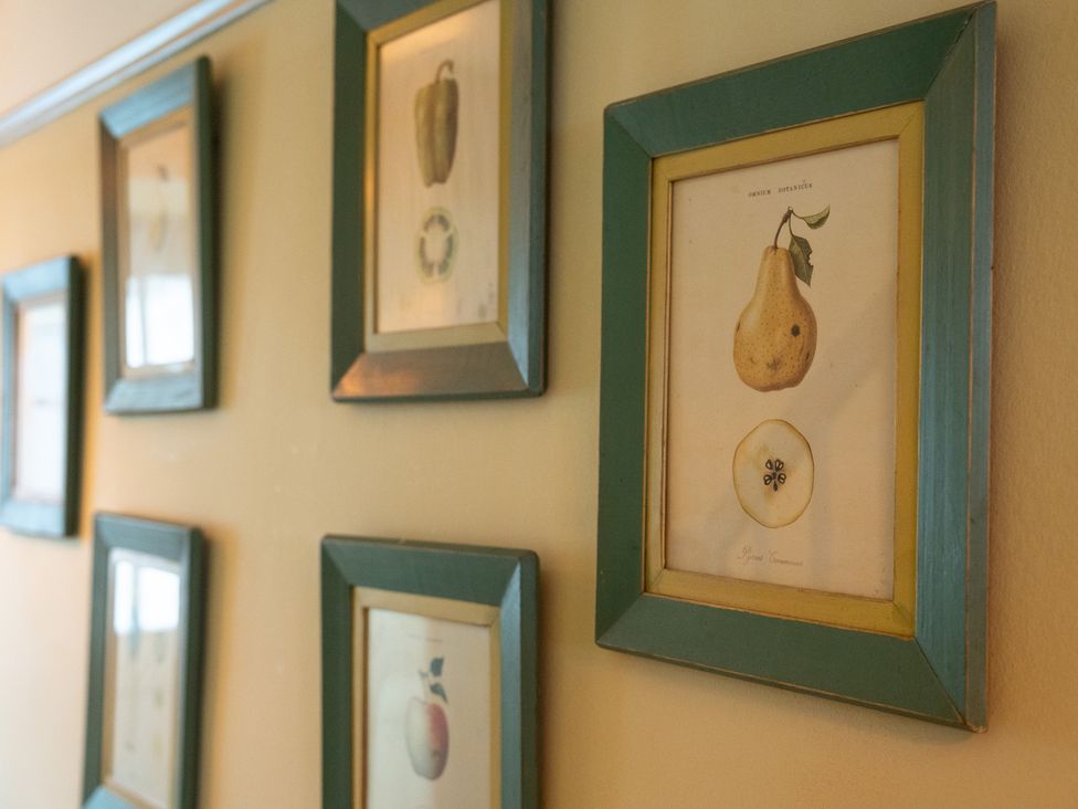 A collection of framed fruit illustrations on a wall at Churchill Cottage Bishop Auckland