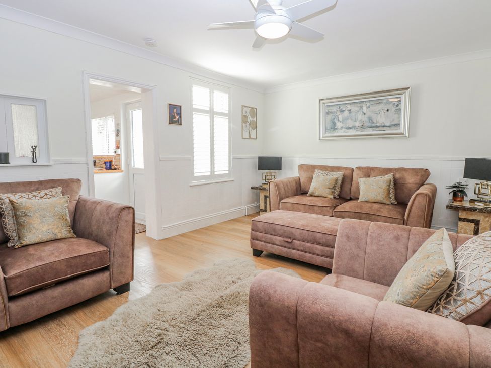 A living room with a sofa and armchair at 17 Woodside Avenue in King's Lynn