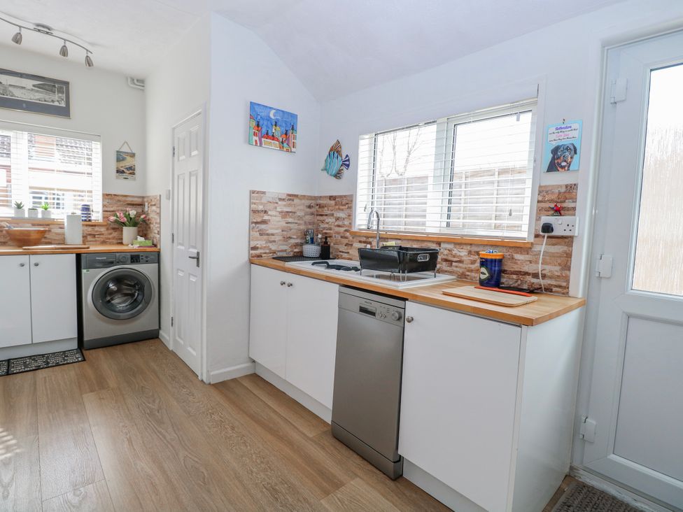 A kitchen with washing machine and sink at 17 Woodside Avenue in King's Lynn