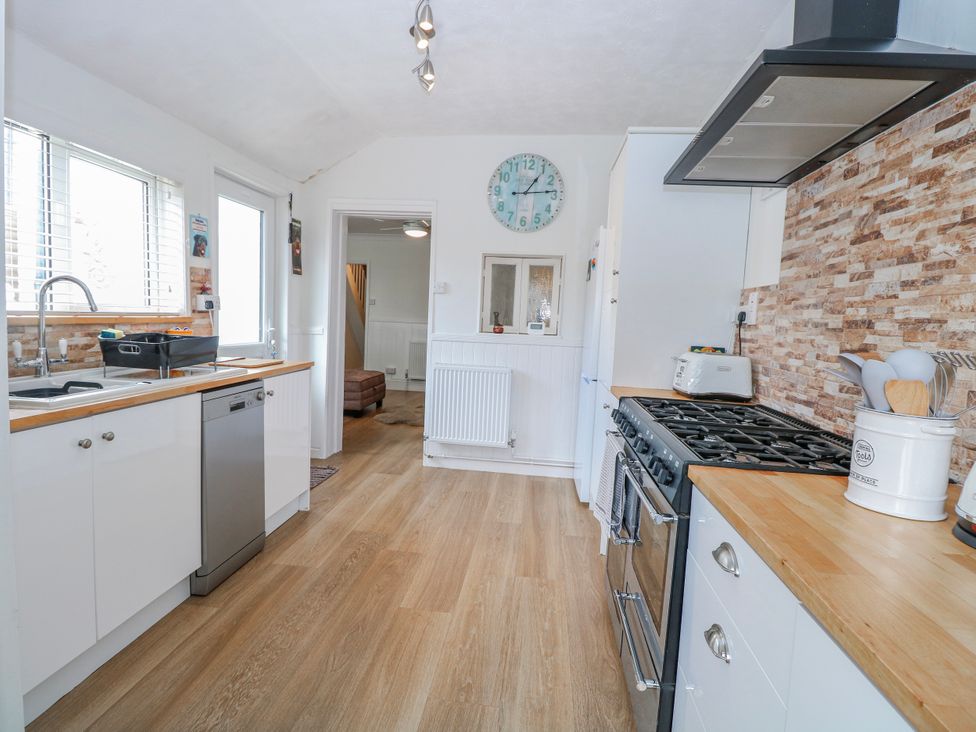 A kitchen with a sink and gas stove at 17 Woodside Avenue in King's Lynn