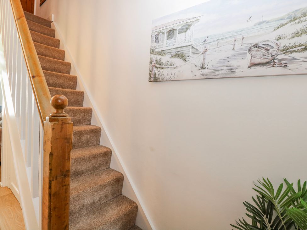 A hallway with stairs and a painting at 17 Woodside Avenue in King's Lynn