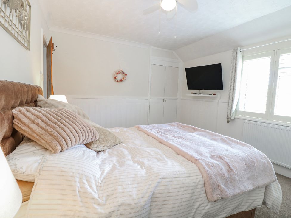 A bedroom with a bed and television at 17 Woodside Avenue in King's Lynn