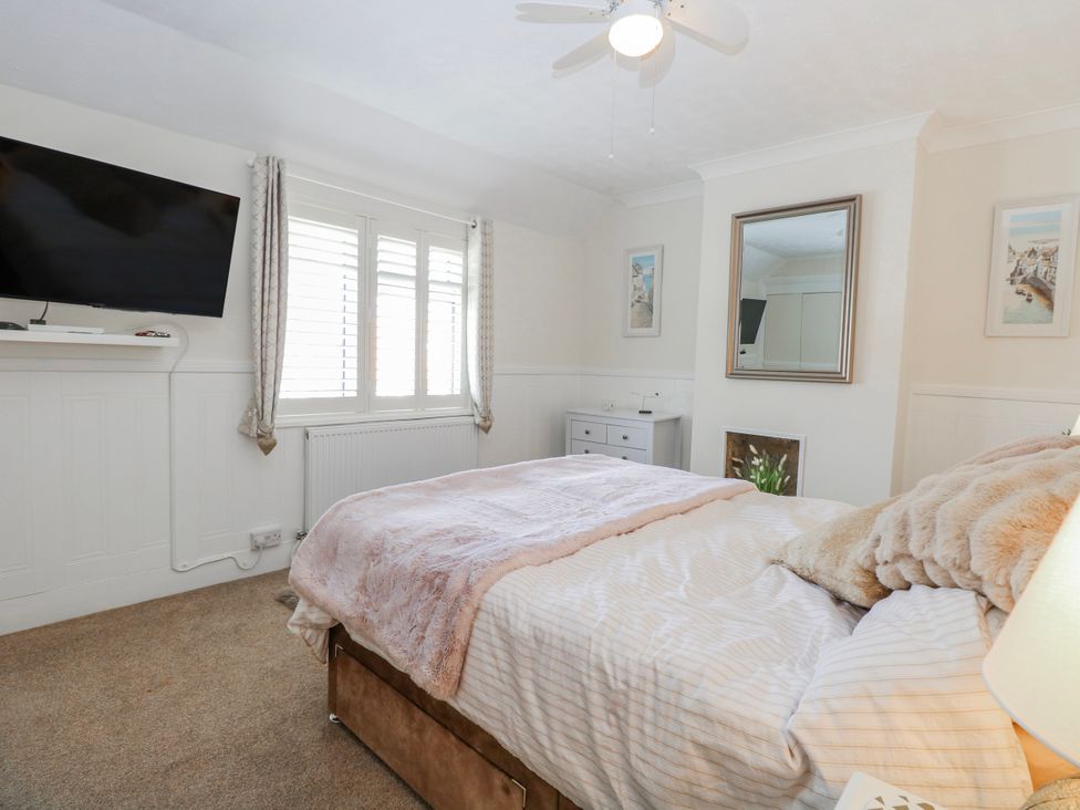 A bedroom with a bed and television at 17 Woodside Avenue in King's Lynn
