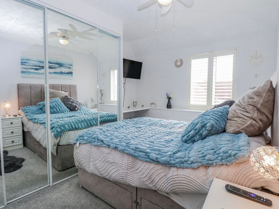 A bedroom with a bed and mirrored wardrobe at 17 Woodside Avenue in King's Lynn