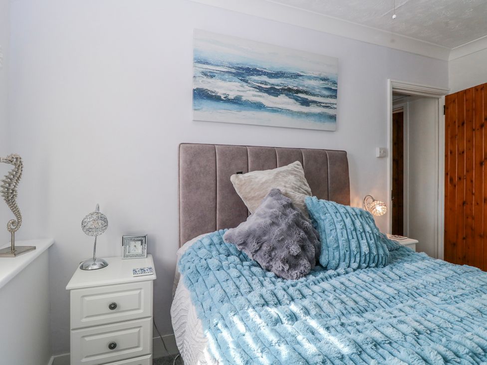 A bedroom with a bed and nightstand at 17 Woodside Avenue in King's Lynn