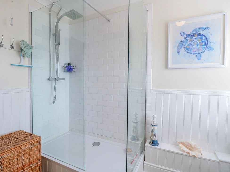 A bathroom with a shower and decorative items at 17 Woodside Avenue in King's Lynn
