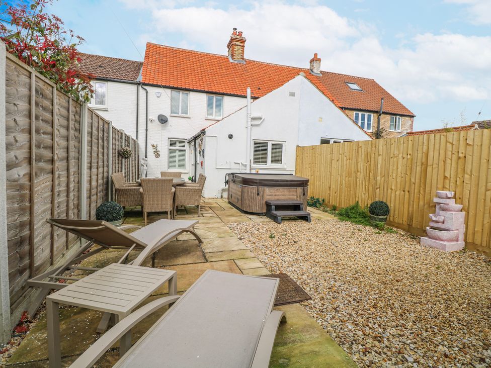 A garden with a hot tub and seating area at 17 Woodside Avenue in King's Lynn