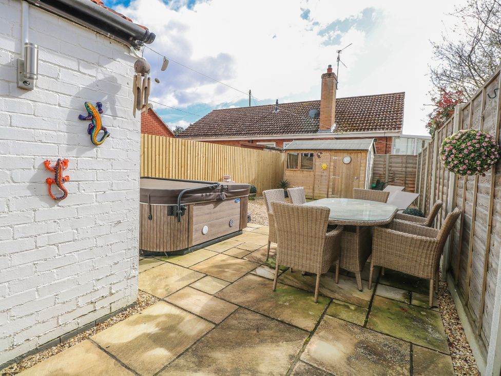 A garden with a jacuzzi and seating area at 17 Woodside Avenue in King's Lynn