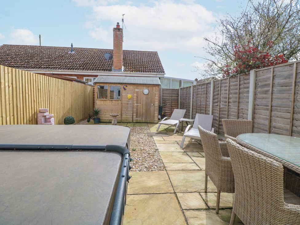 A garden with seating and a shed at 17 Woodside Avenue in King's Lynn